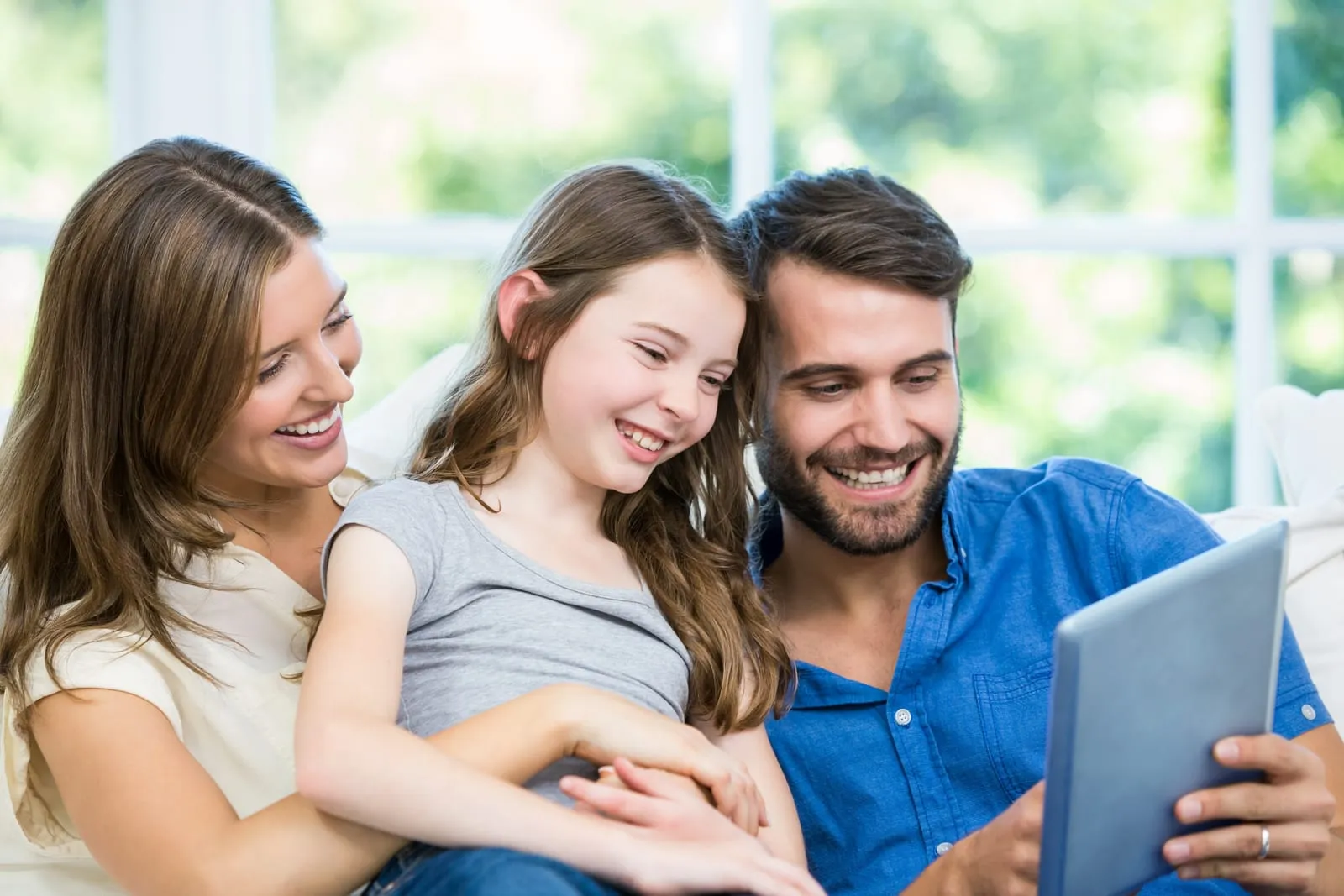 Familia en su casa mirando juntos una tablet