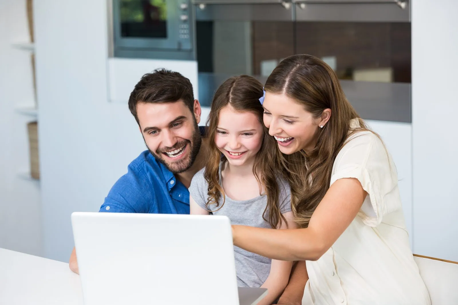 Familia mirando junta una notebook en su casa